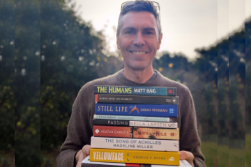 Geoff holding book club books